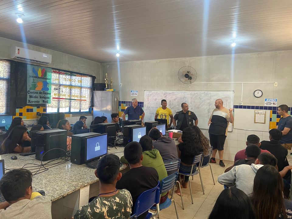 Alunos indígenas em sala de aula na frente de computadores